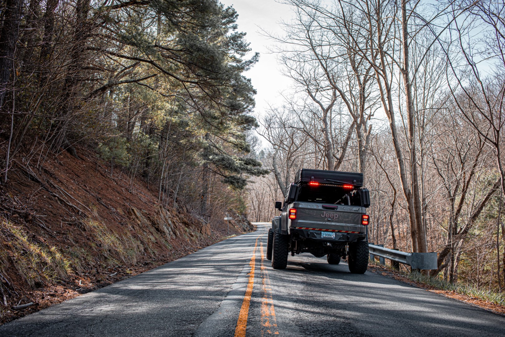Jeep Gladiator Mojave driving on a wooded mountain road